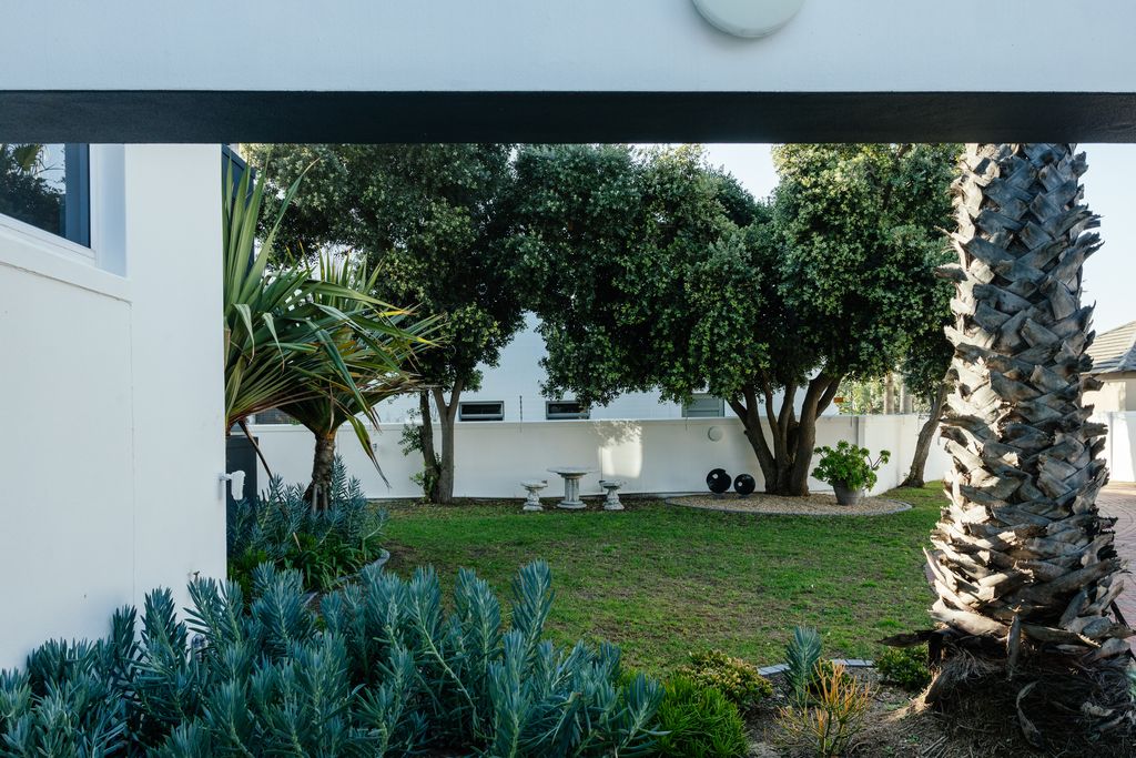 Modern residential garden with lush greenery and stone seating