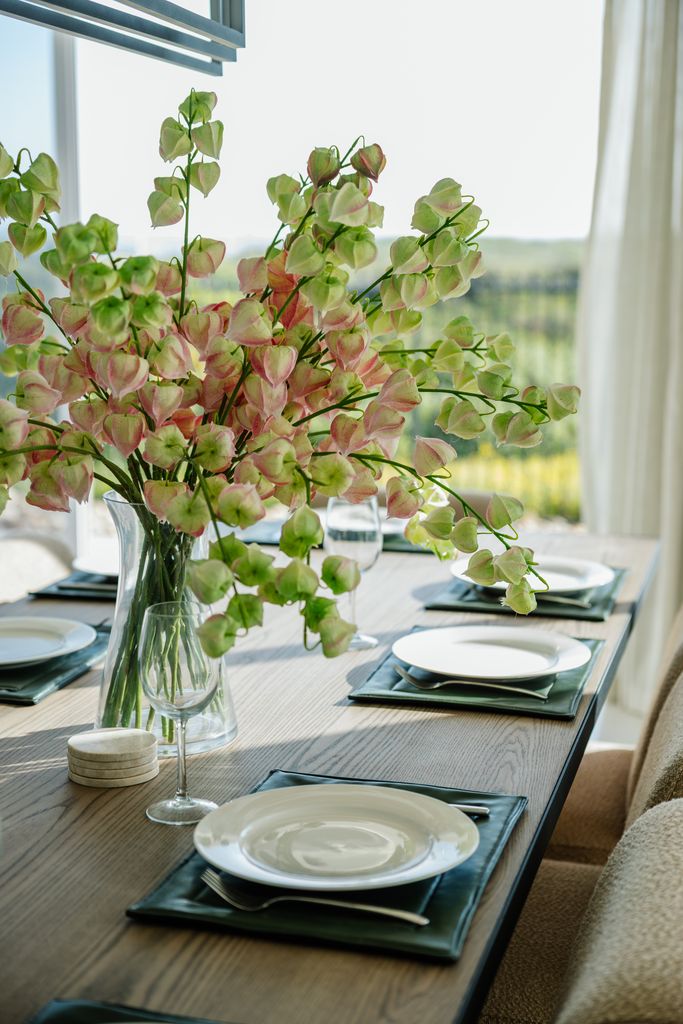 Set dining table with green pod floral centerpiece