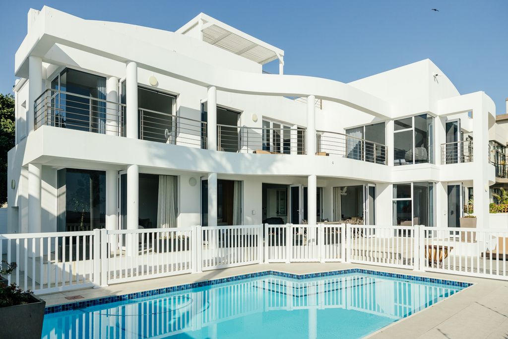 Modern white beach house with swimming pool and balcony