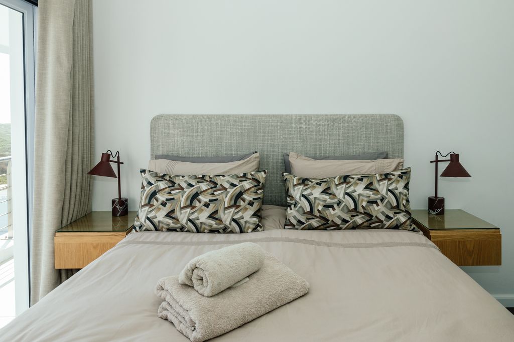 Modern bedroom with patterned pillows and folded towels