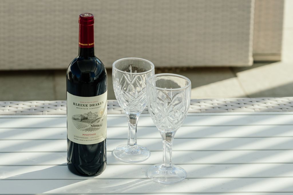 Kleine Draken Pinotage wine bottle with two crystal glasses