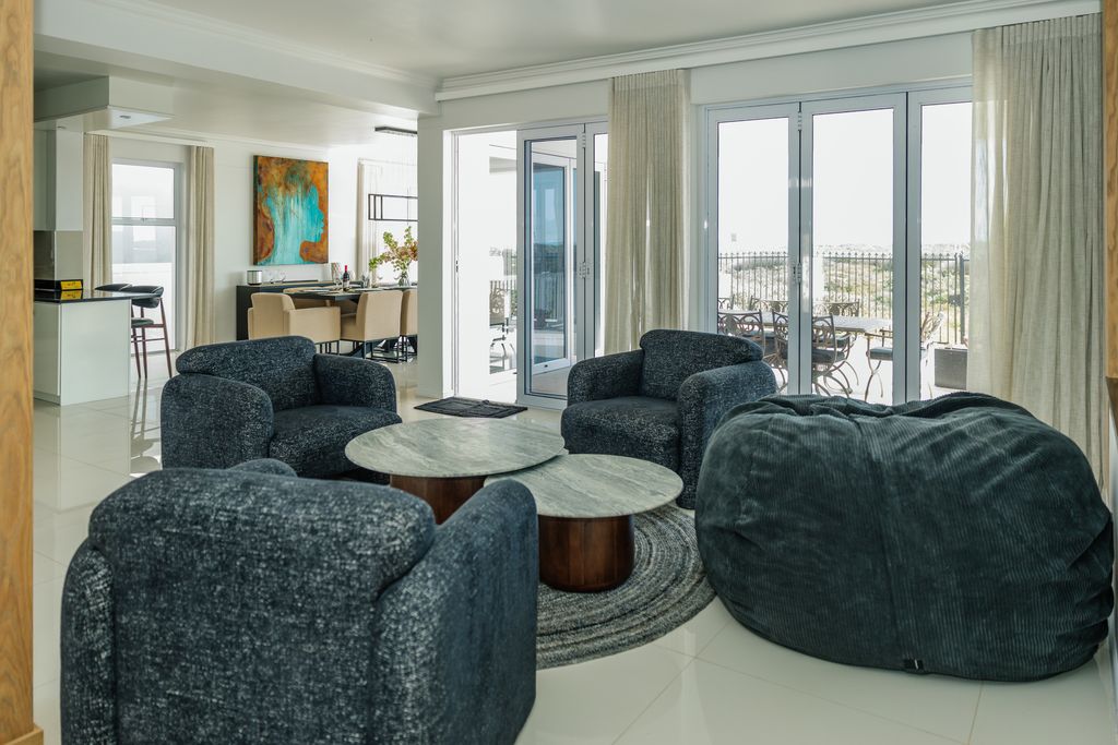 Modern living room with dark armchairs and bean bag.