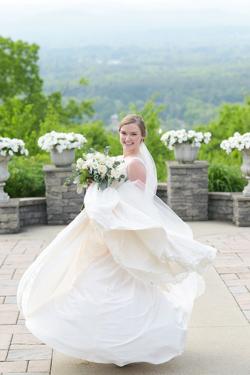 Katie Logan, founder and CEO of Logan Planning Solutions, a micro wedding and elopement planner in Boston, Massachusetts, New England, on her wedding day at the Log Cabin in Easthampton, Massachusetts. She is in a white bridal gown with a large bouquette and smiling at the camera.