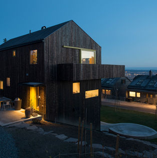 North-west view with entrance and cantilevered balcony; shou sugi ban inspired charred/oiled spruce; southward view to Oslo fjord.