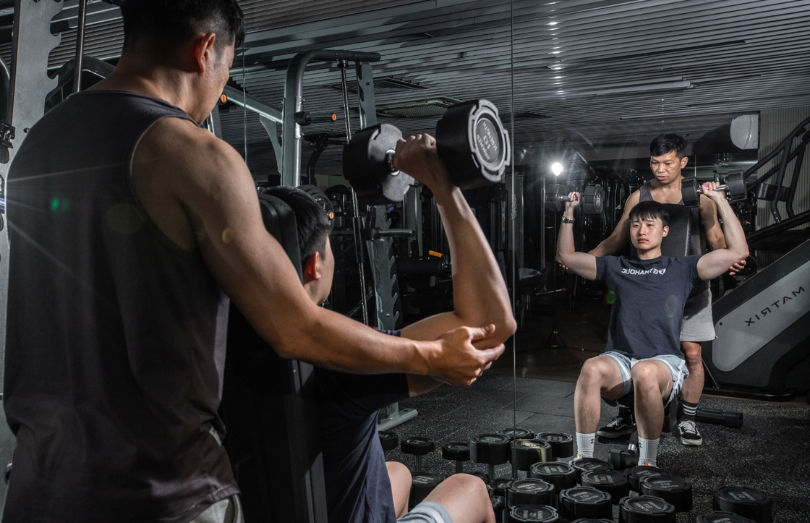Three Gym的私人健身教練正在指導學生正確的運動姿勢