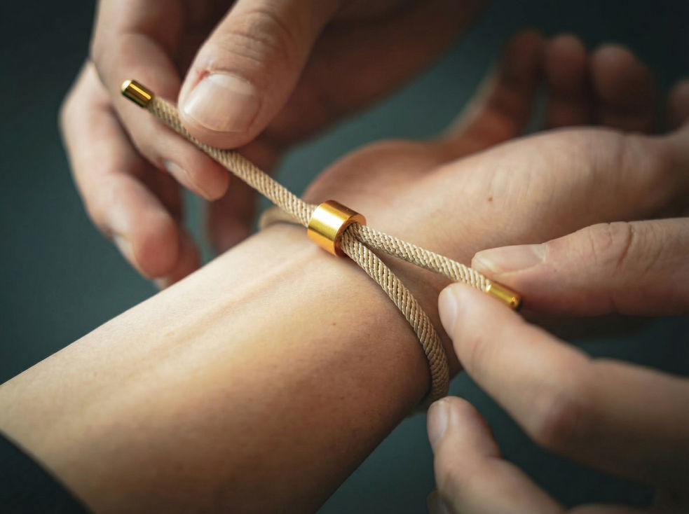 Main ajustant un bracelet sur un poignet.