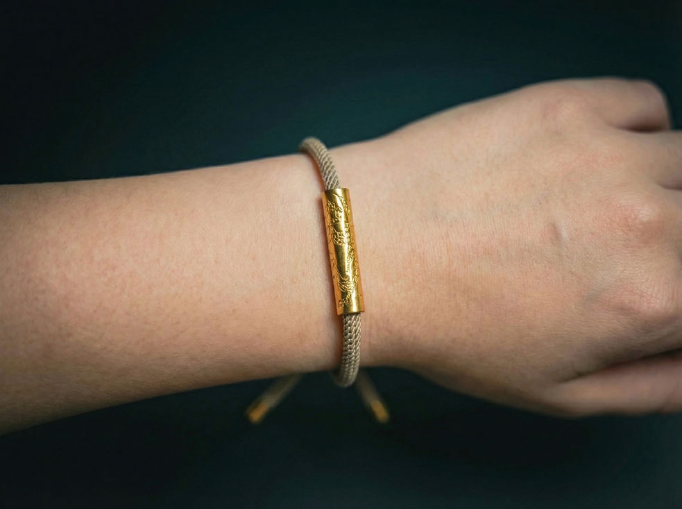 Bracelet à cordon avec tube doré sur un poignet