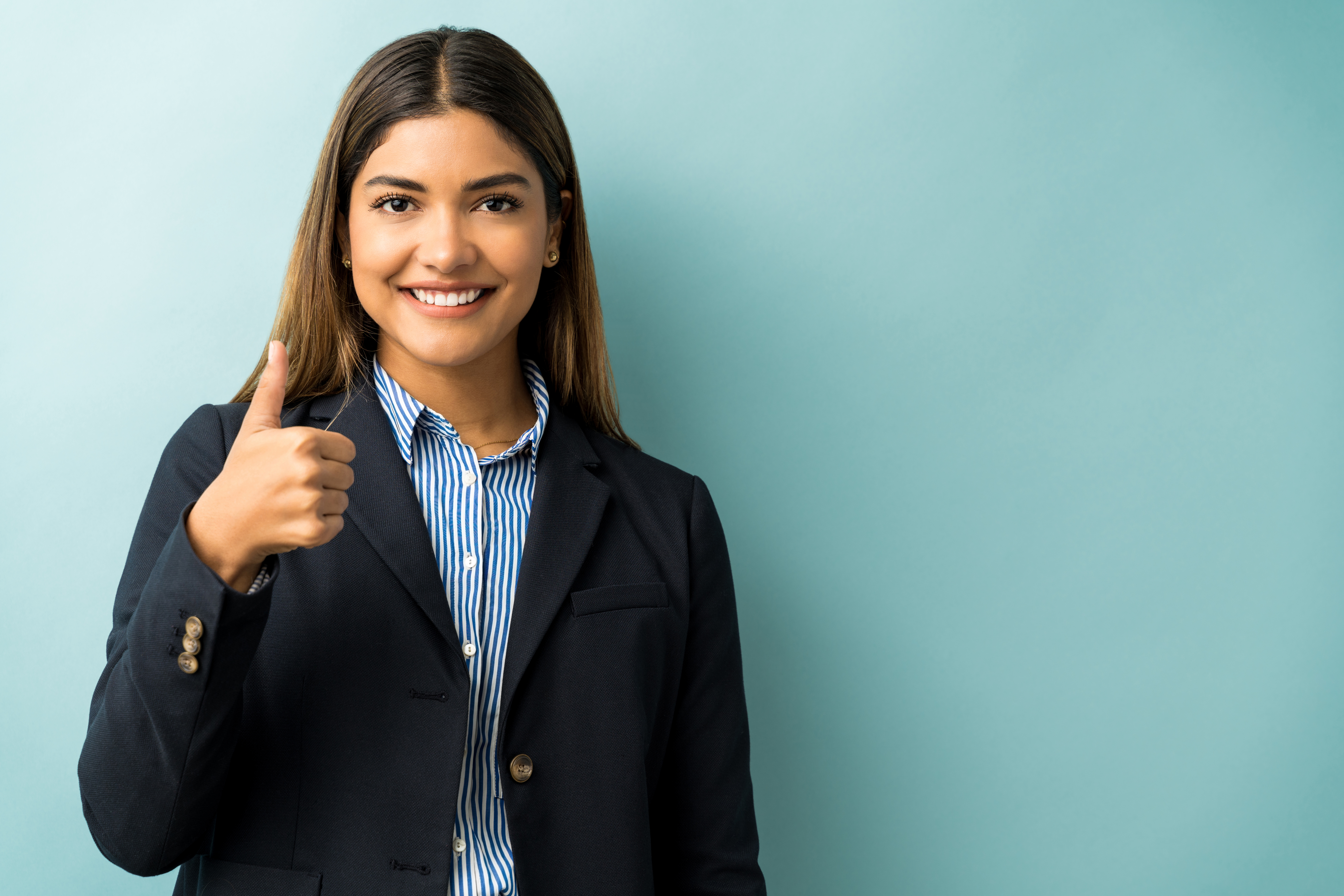 hispanic-female-executive-gesturing-thumbs-up-against-isolated-background.jpg