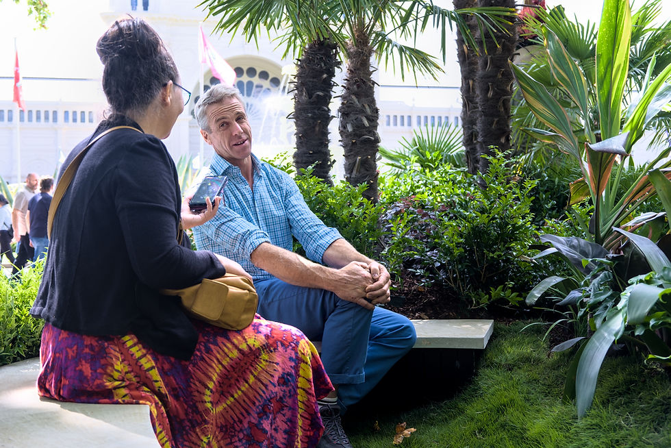 Woman interviewing man in show garden