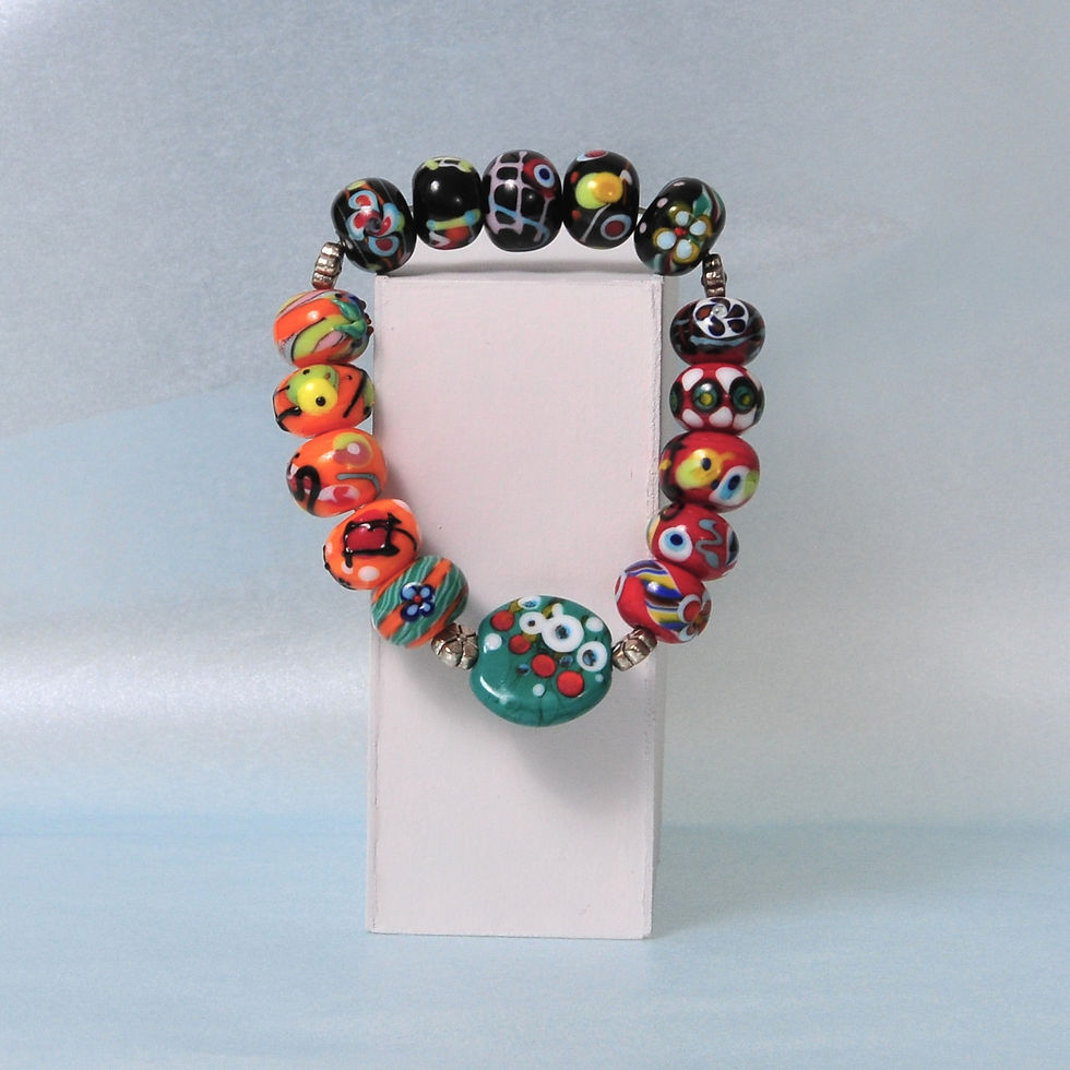 kolorowa bransoletka zawieszona na białej podstawie