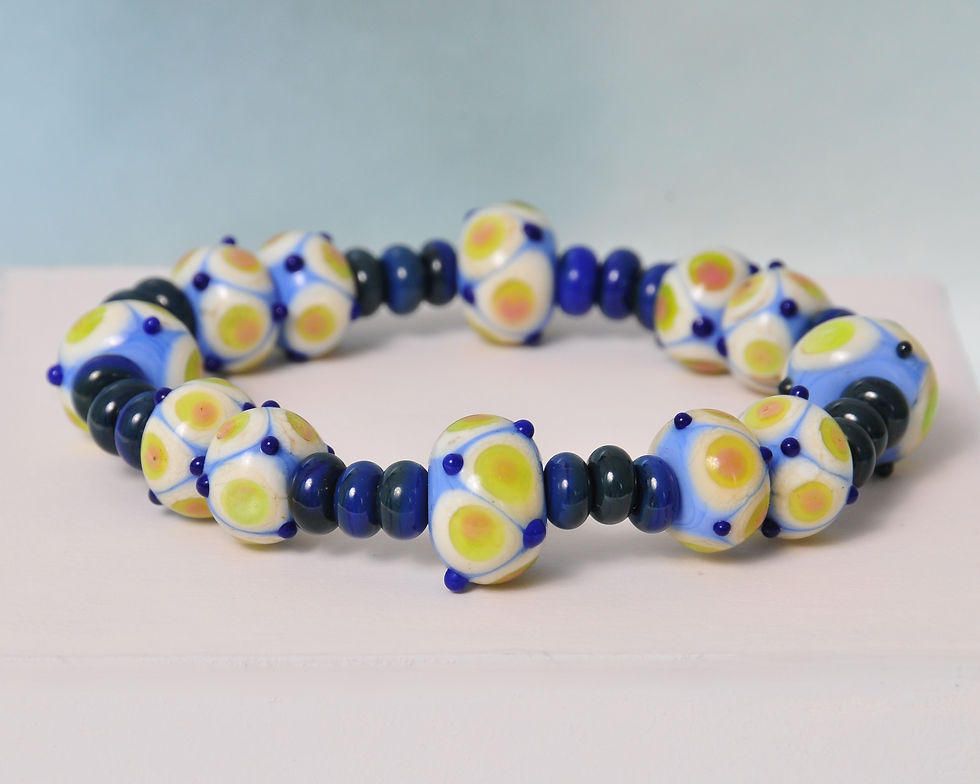 bransoletka granatowo niebieska leżąca na białej podstawie