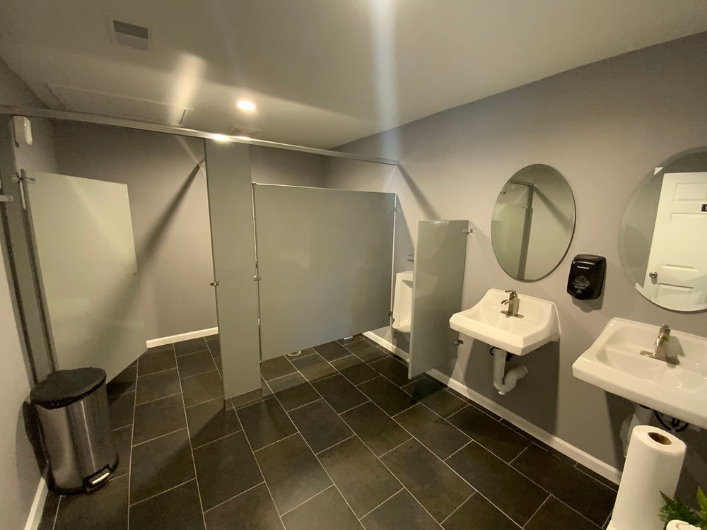 Restroom with two sinks and dark floor tiles.