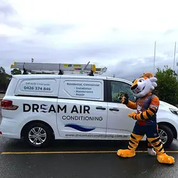 The All Saints Toongabbie Tigers mascot proudly poses next to a white Dream Air Conditioning service