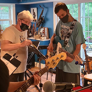 JAM's founder, Kim McCord, assisting one of JAM's musicians on guitar.