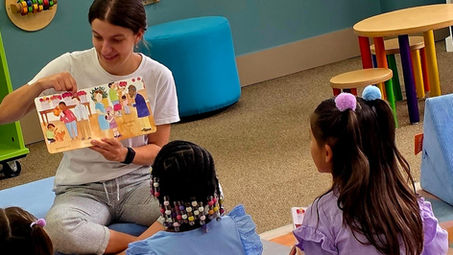 A girl reads to three children.