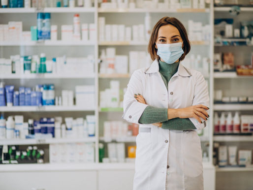 This is a photo of a pharmacist with her arms crossed in a pharmacy