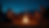 Eye-level view of a lively campfire gathering under the starry sky