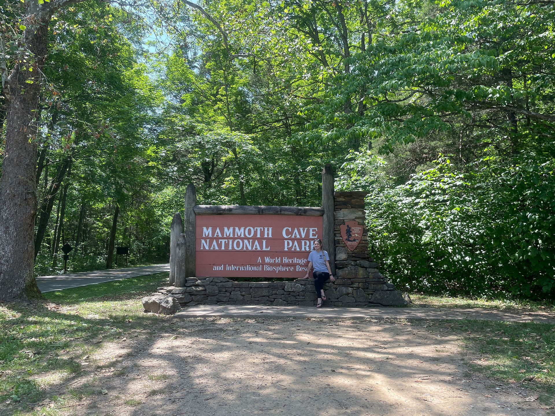 Mammoth Cave National Park sign with visitor standing nearby