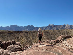 Girl hiking with back to camera in at overlook
