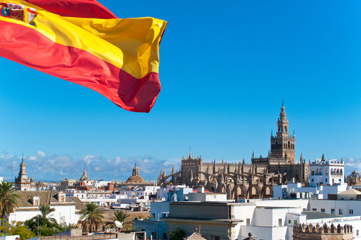 PDCosenza Bandera española ondeando con la catedral de fondo, Sevilla, España