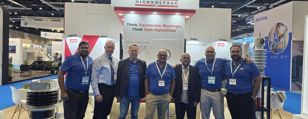 Group of people posing in front of Yash Highvoltage Ltd. booth at exhibition