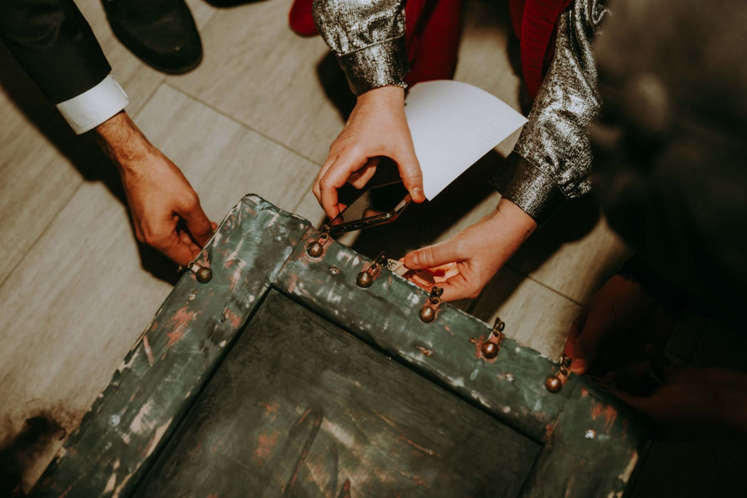 Gros plan sur mains ouvrant un coffre à cadenas durant l’escape game mariage MadyOui