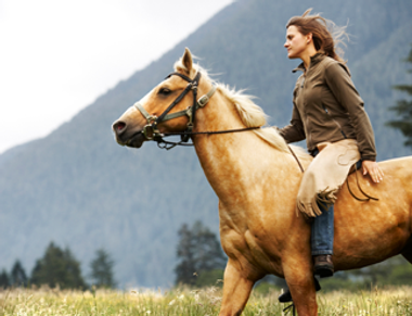 Frau auf galoppierenden Pferd