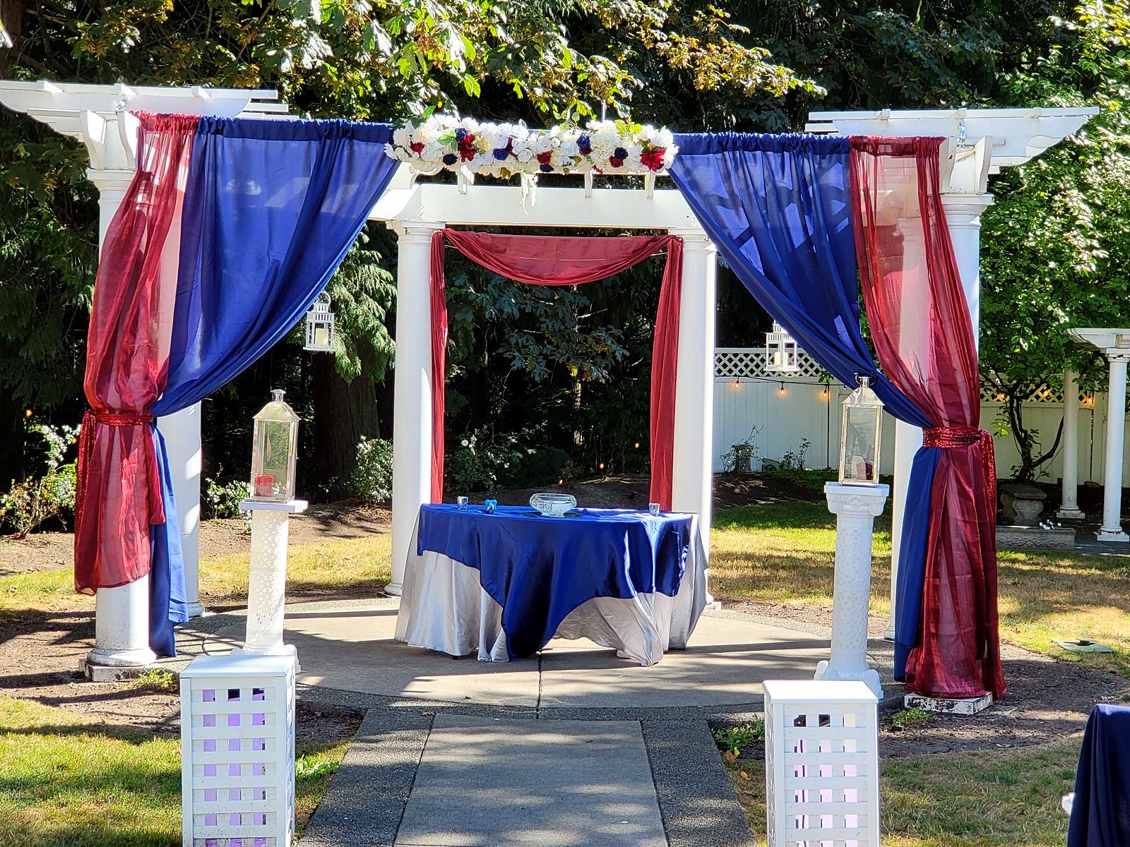 Pergola draped in navy and burgundy for an outdoor ceremony