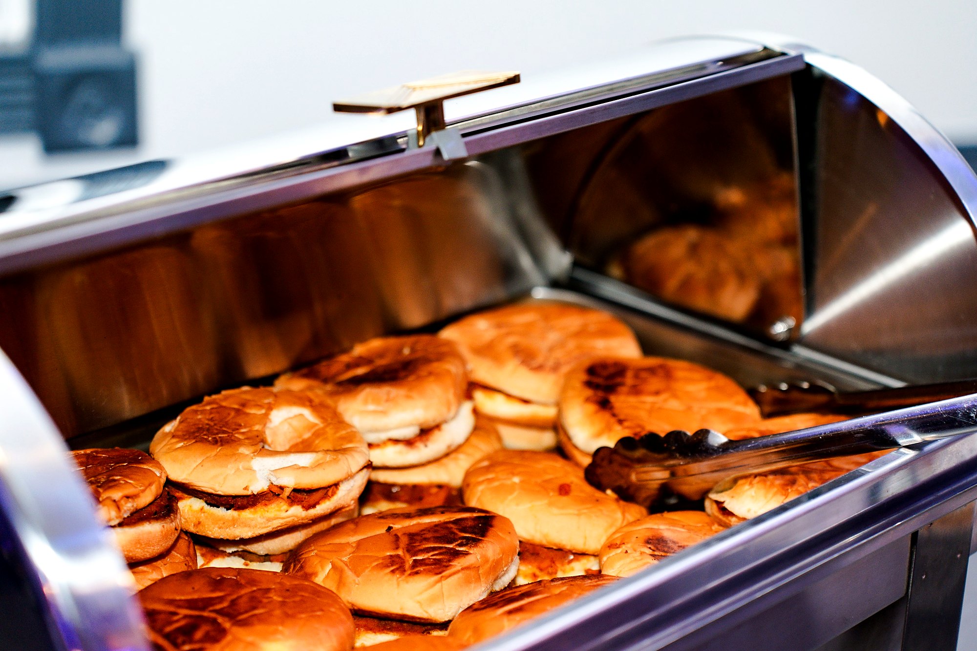 Toasted sliders kept warm in a roll-top chafing dish