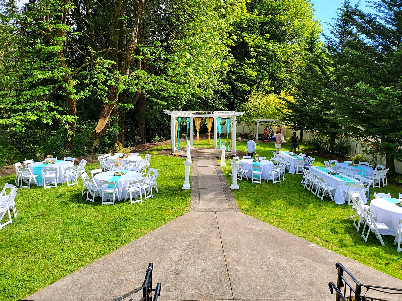 Outdoor reception on the lawn – tables set along the garden path to the pergola