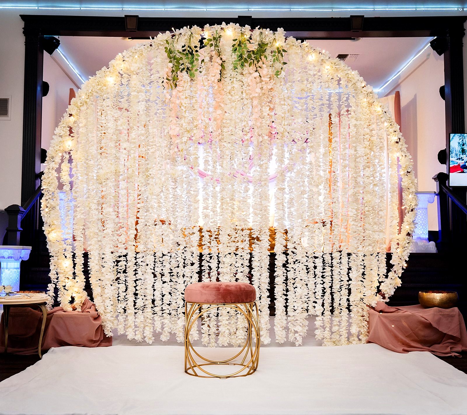Indoor floral moon arch with cascading white wisteria and fairy lights