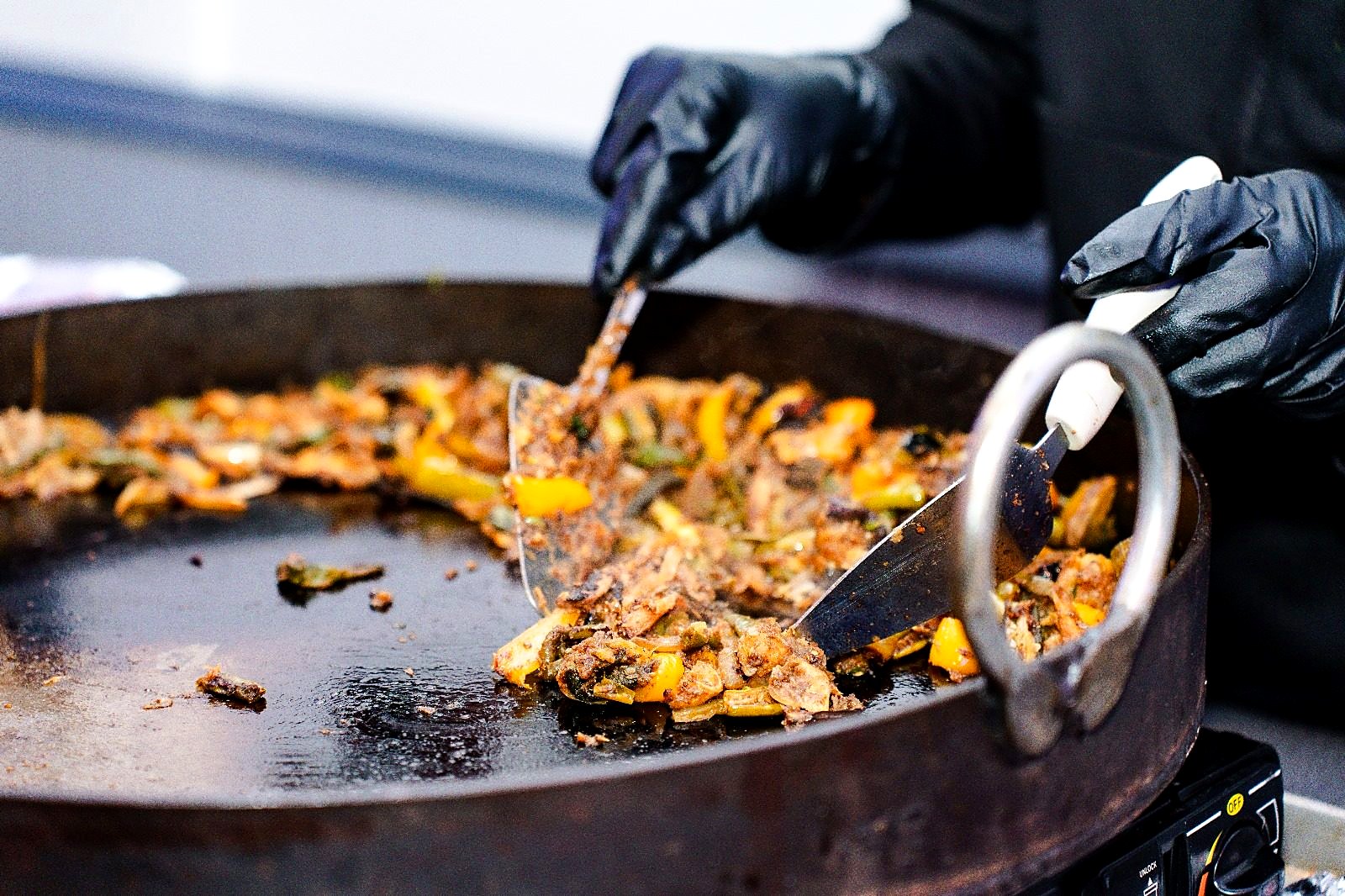 Live tawa station – chef tossing spiced vegetables on a large iron griddle