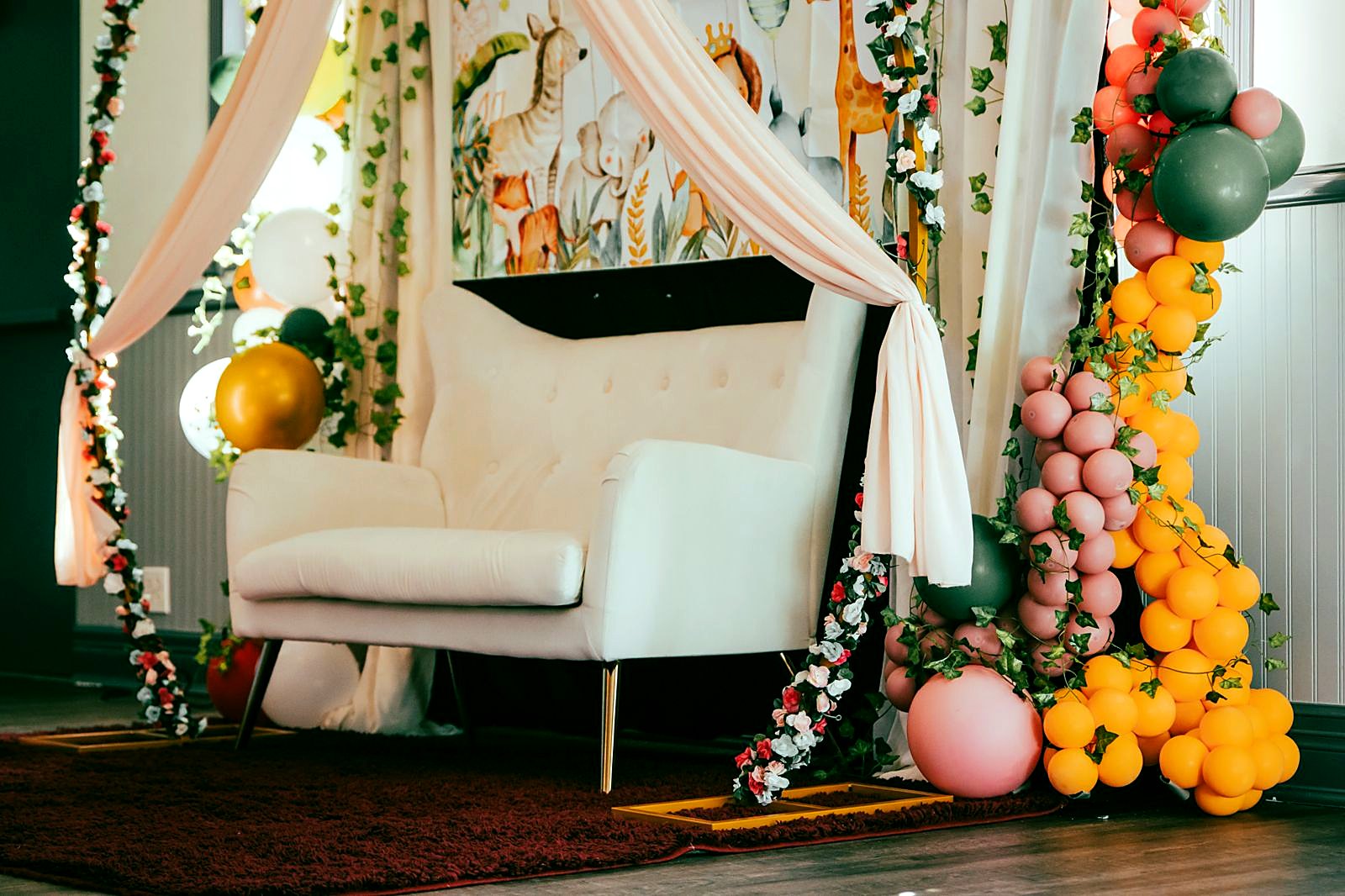 Baby shower lounge with a floral swing and balloon garland
