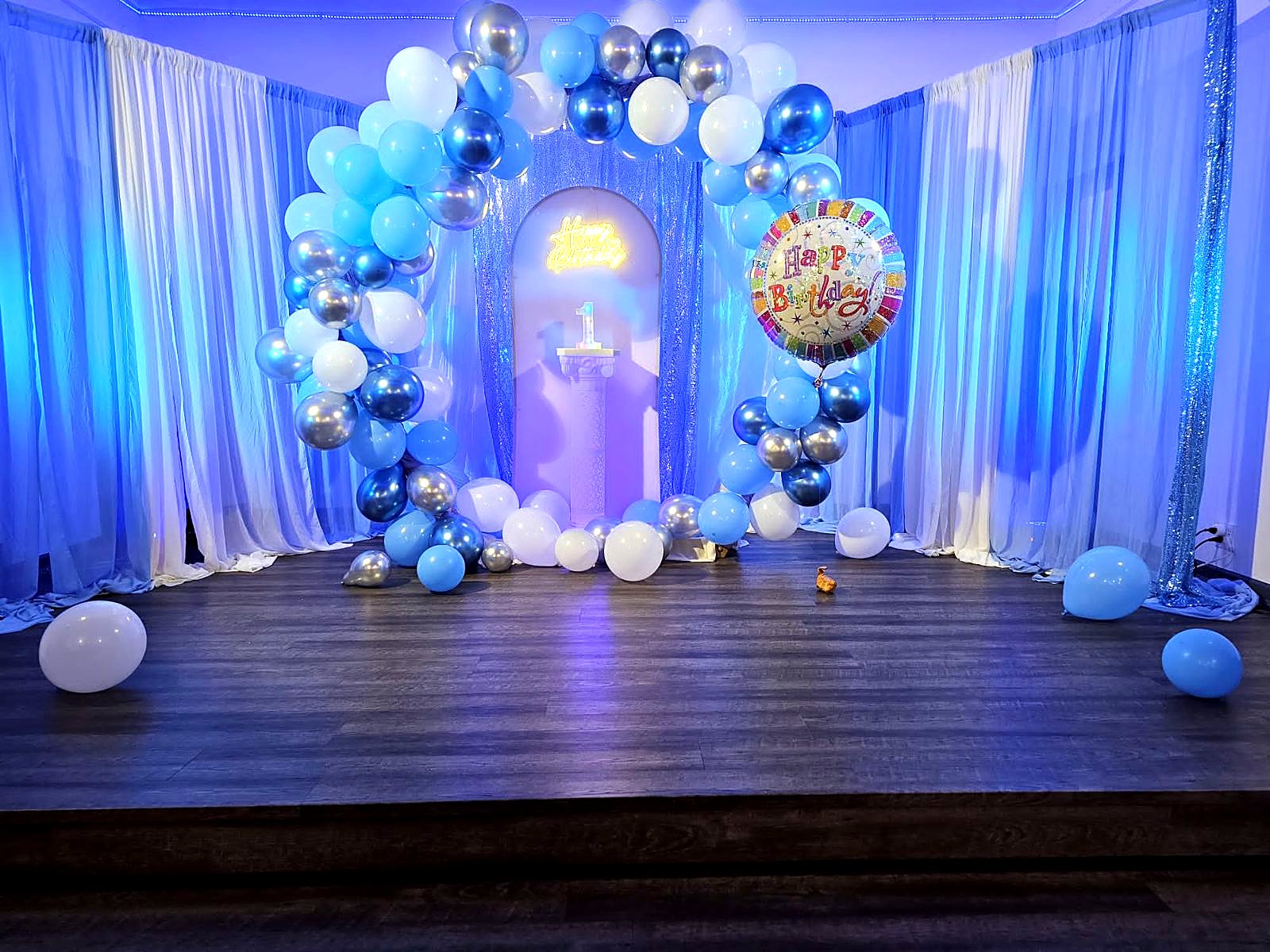 Blue balloon arch and stage for a 1st birthday