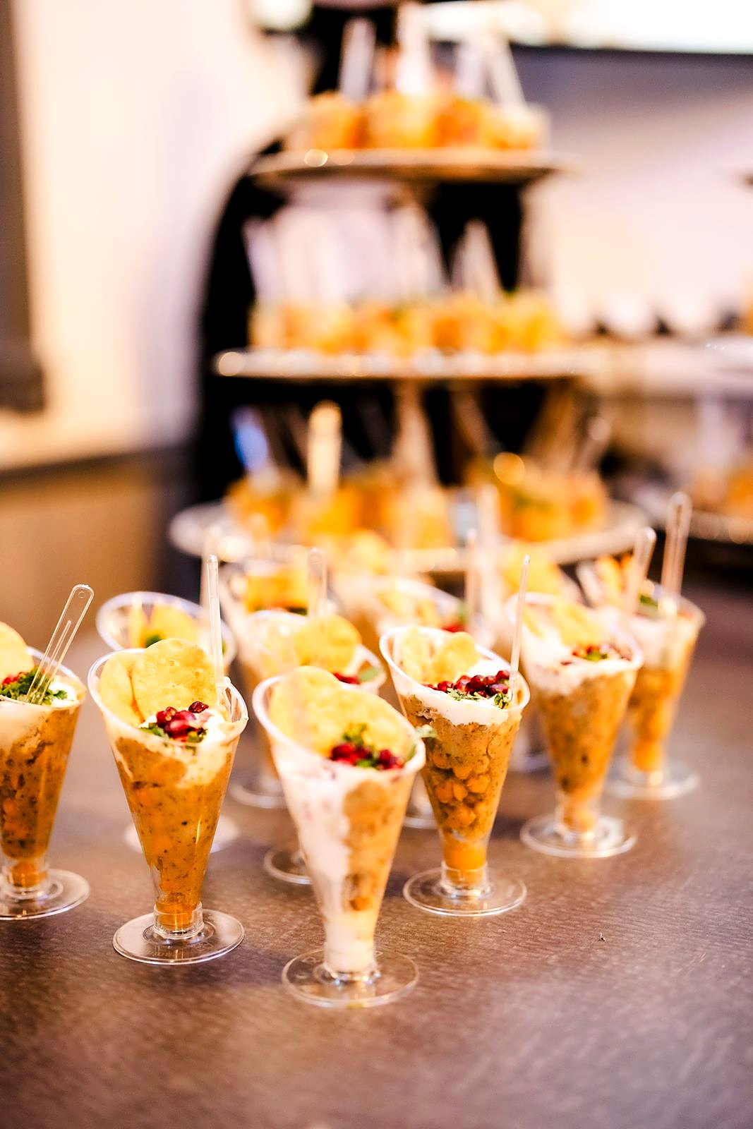Layered chaat cups topped with yogurt, pomegranate and papdi