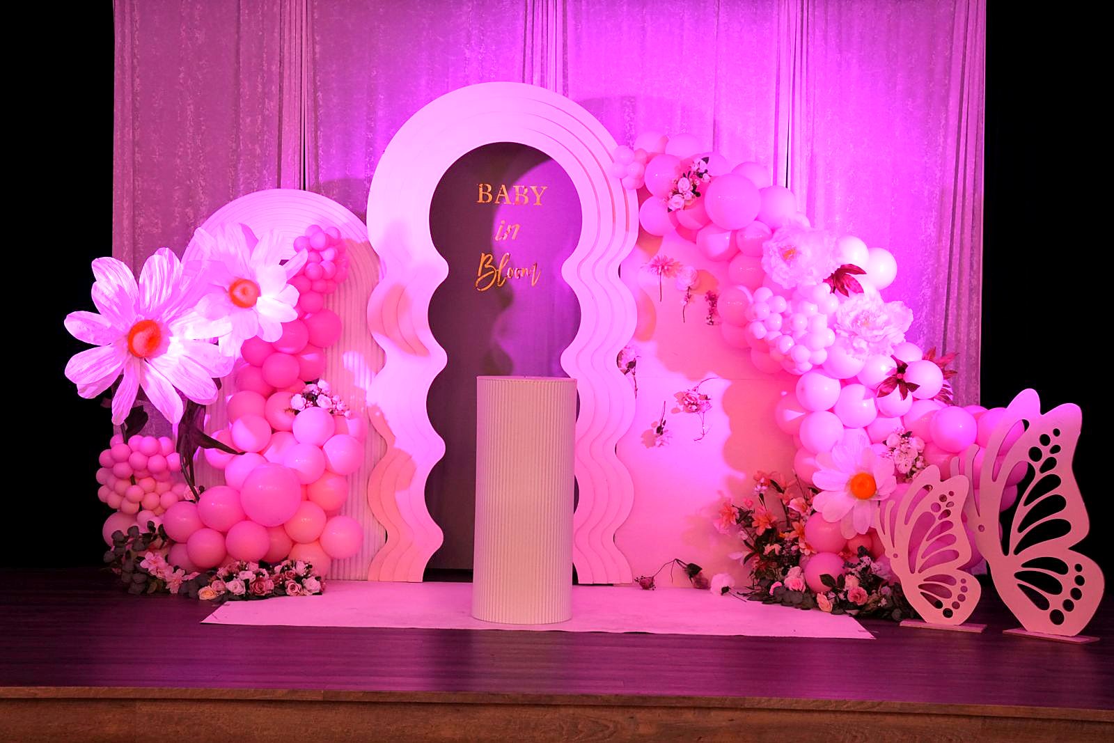 Pink baby shower arch with flowers and butterflies