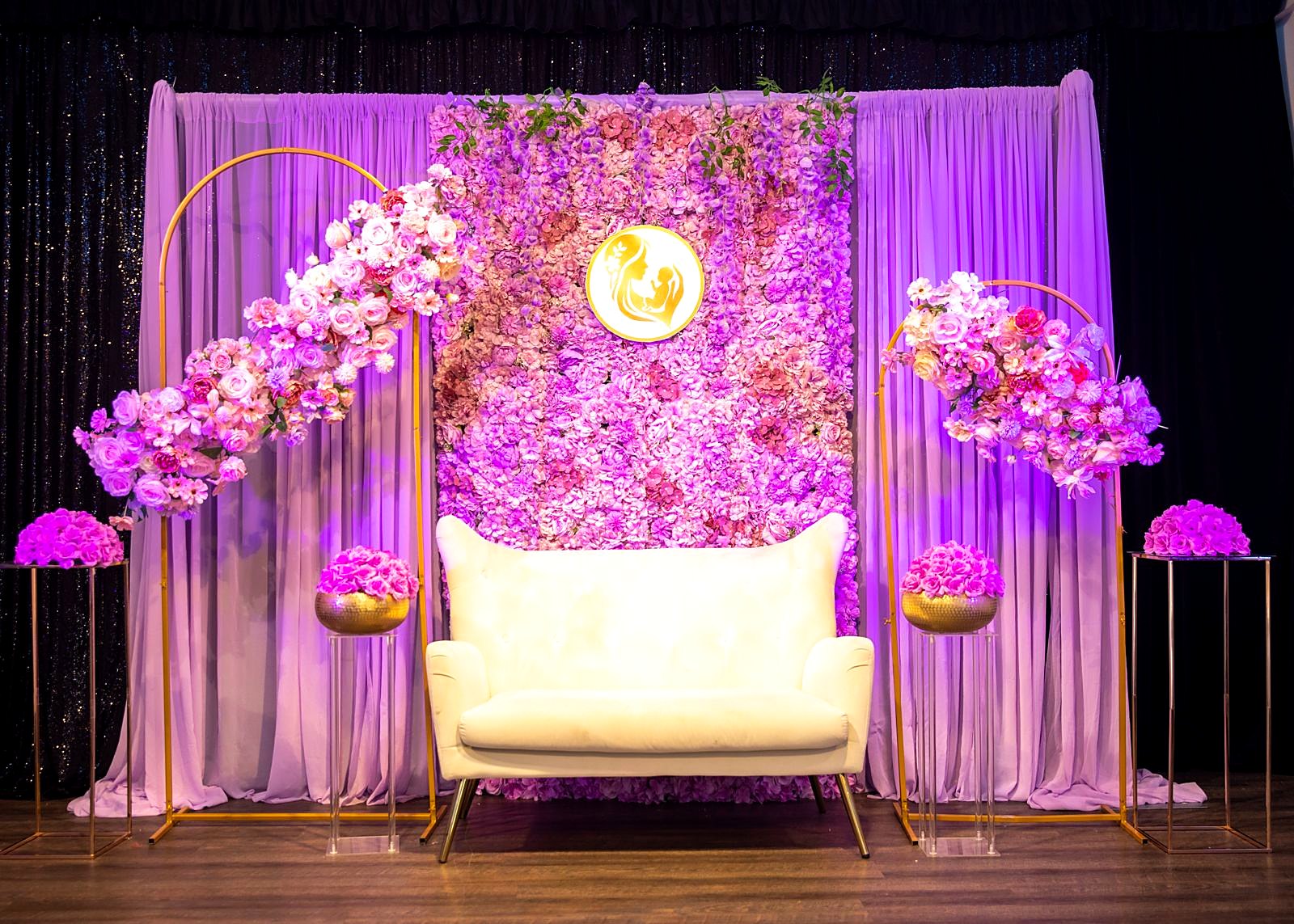 Floral sweetheart stage with a white loveseat and orchids