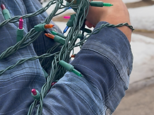 Holiday lights wrapped around the arm of a Range Window Cleaning employee