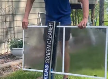 A Range Window Cleaning employee professionally cleaning the window screen