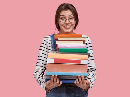 Girl holding a stack of books. 
