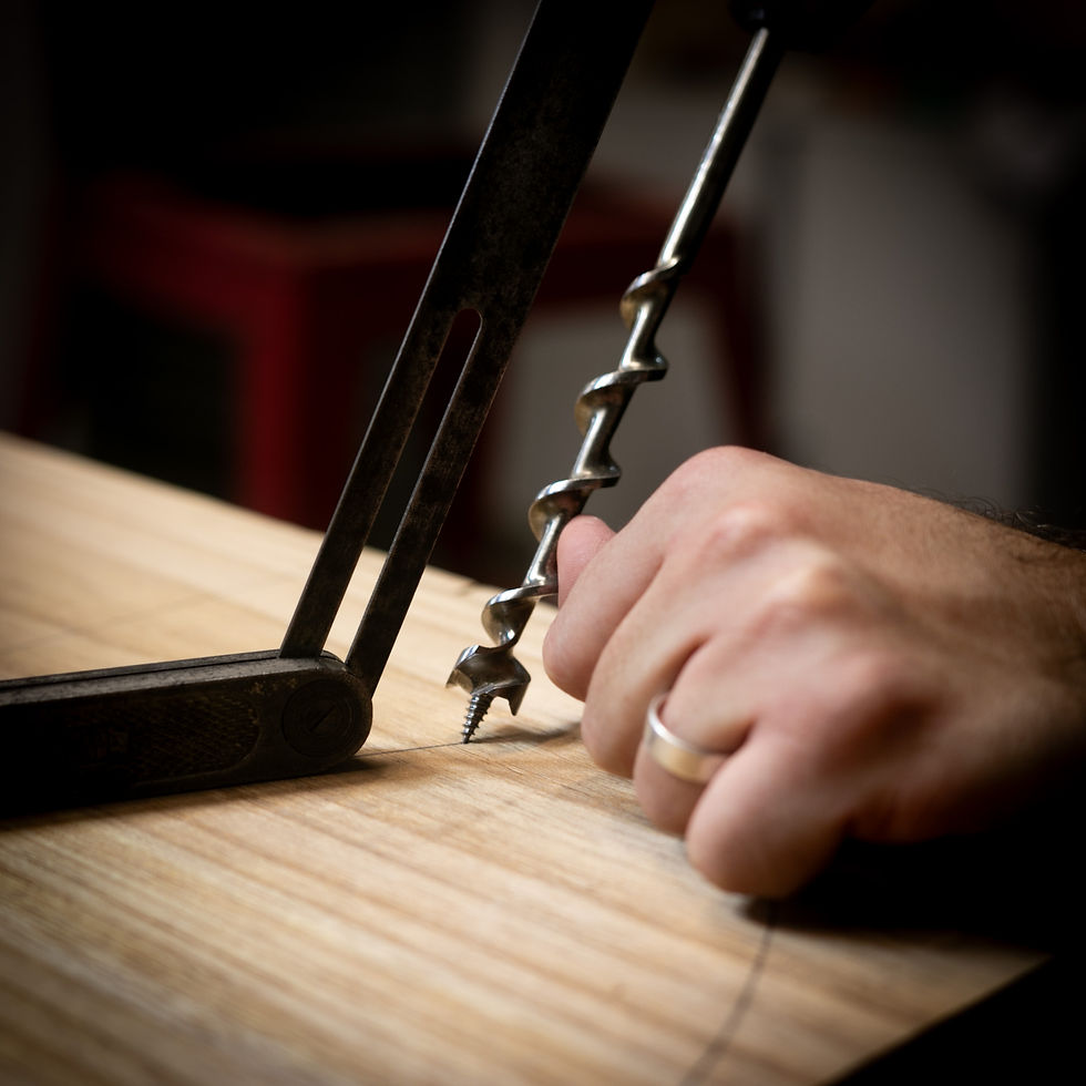 Artesão usando medidor de ângulo para fazer furo para os pés da cadeira