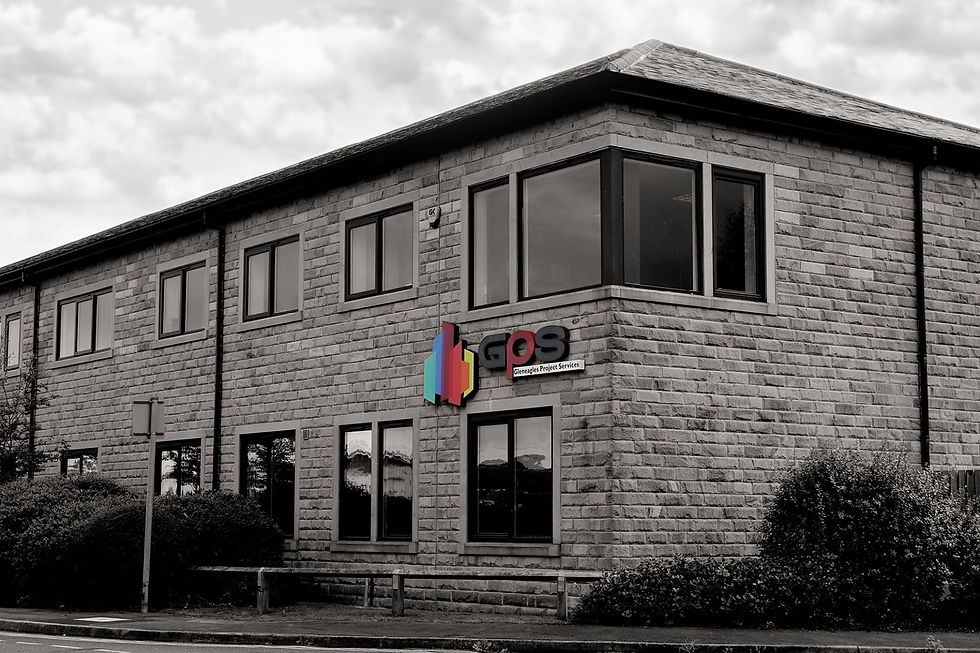 Office building with large windows and GPS Gleneagles Project Services sign, seen under a cloudy sky.