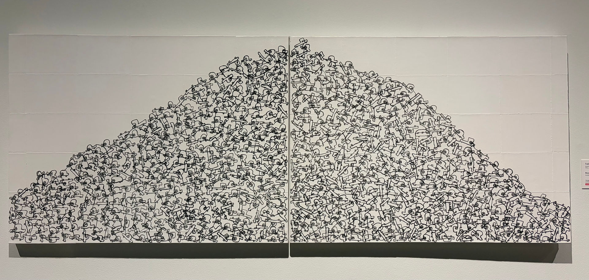 Dense black-and-white ink artwork of layered abstract figures forming a mountain shape, Memphis Brooks Museum of Art