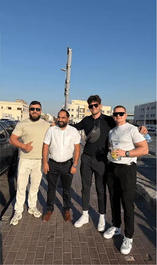Four men smiling for a photo outdoors