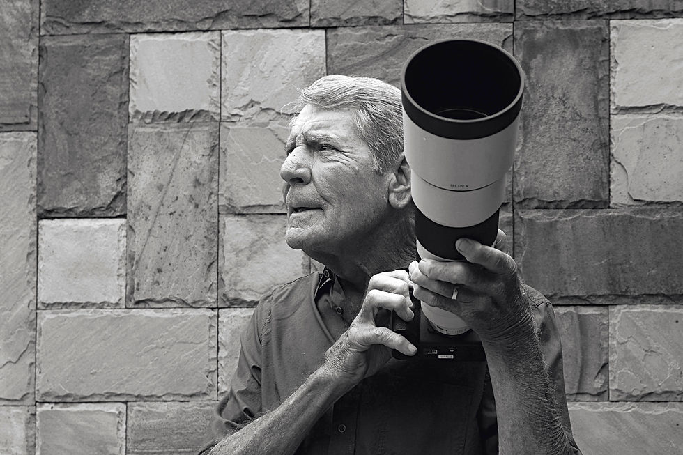 a man, Gerald Hinde, holding his camera