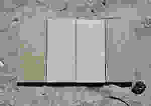 four composite deck board samples on beach sand