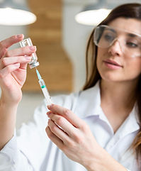 female-scientist-with-safety-glasses-holding-syringe-with-vaccine-lab.jpg