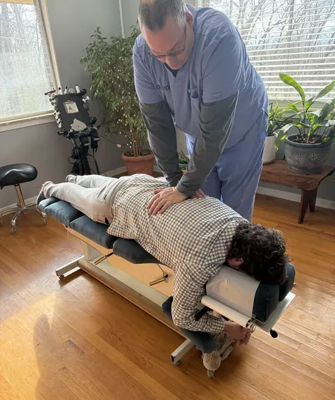 Doctor Holt performing a back adjustment on a patient