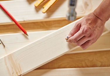 senior-carpenter-tries-hammer-nail.jpg