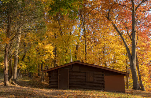 A cabin in the woods surrounded by beautiful fall trees